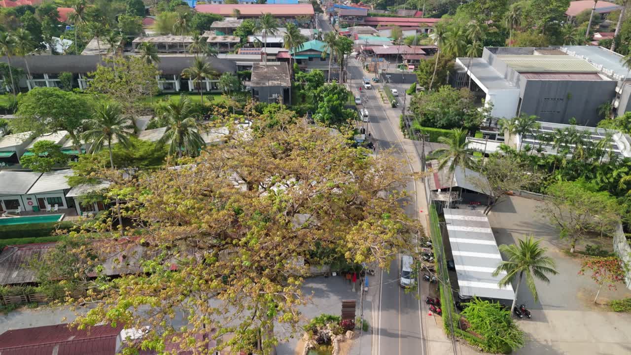 ascending aerial footage of Kai Bae village with roads, hotel accommodation and roof tops on Koh Chang island