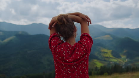 Back-view-relaxed-girl-standing-slope-putting-hands-on-head-cloudy-day-close-up.