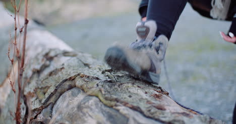 woman tying shoe on tree trunk 1