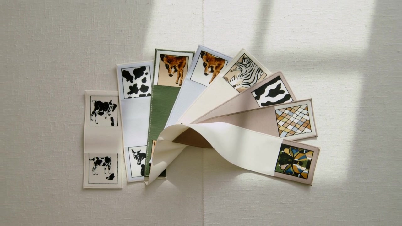 Sollevando un lungo campione su campioni di tessuto sotto l'ombra di una finestra, la luce del sole inizia a mostrare un motivo a macchie di mucca o zebra.