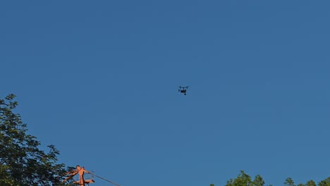 un dron comercial volando sobre los árboles en un área urbana durante un evento