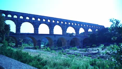 Pont-Du-Gard-Hinter-Einer-Steinmauer-über-Dem-Fluss,-Gebäude-Der-Progressiven-Wasserförderung-Röhmer-Zurr