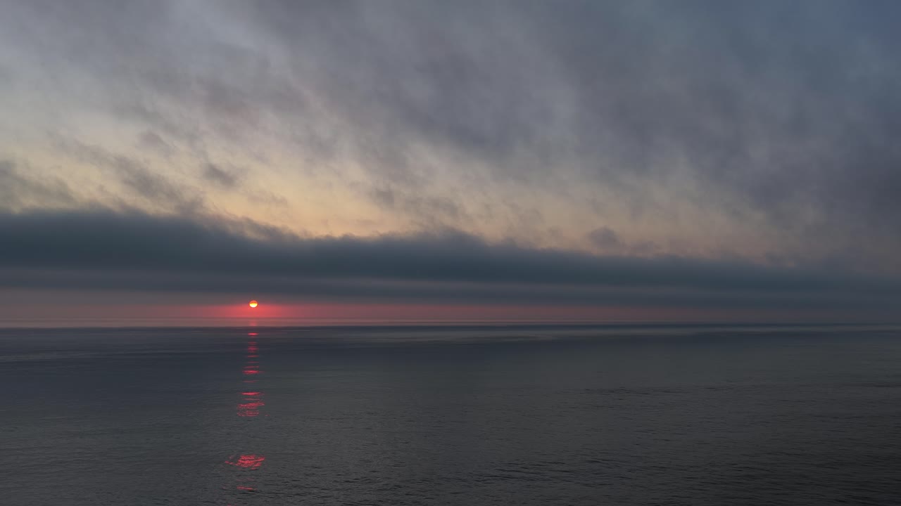 Sunset with low clouds over the ocean