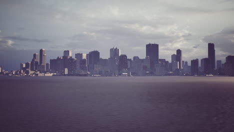 city skyline during twilight with clouds above the water at dusk