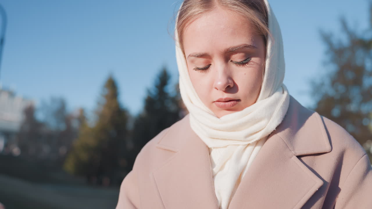 Valkoinen nainen lukemassa muistiinpanoa ruusun kanssa, lähikuva muotokuvasta aurinkoisessa puistossa. Huivi ja takki kehystävät kasvoja, kun käsin kirjoitettu kirje avataan. Ilme muuttuu hitaasti yllätyksestä suruun ja hiljaiseen päättäväisyyteen.