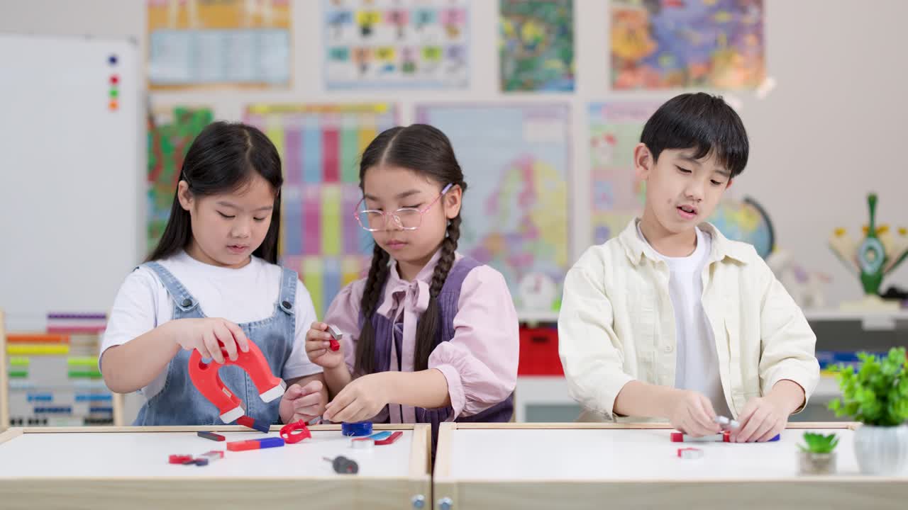 밝게 빛나는 교실에서 세 명의 학생이 참여형 STEM 활동으로 다채로운 자석을 가지고 실험하고 있어요.
