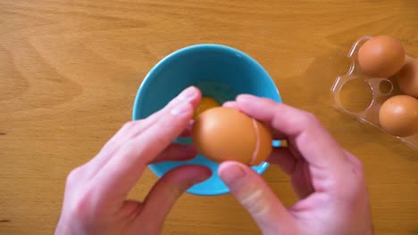 breaking an egg on a bowl, view from the top