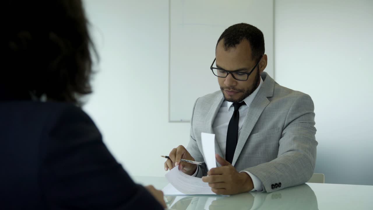 Confident handsome young man signing documents.