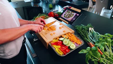 Tabla-De-Cortar-Con-Cuchillo-Y-Zanahoria-Con-Otras-Verduras-Y-Una-Tableta-Con-Recetas