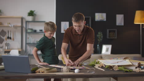 father and son building a kite