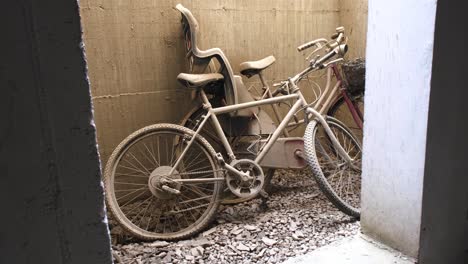 two abandoned bikes with flat tires left leaning