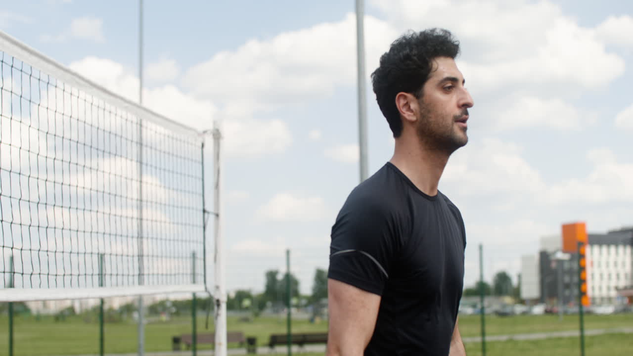 vista lateral del hombre moreno golpeando una pelota de voleibol.