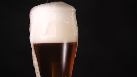 a golden brew with frothy crown, the bubbles rise, the foam pours down