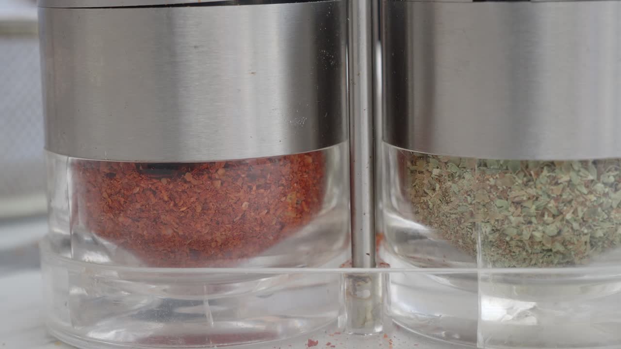 Barattoli per spezie con fiocchi di peperoncino rosso ed erbe aromatiche essiccate