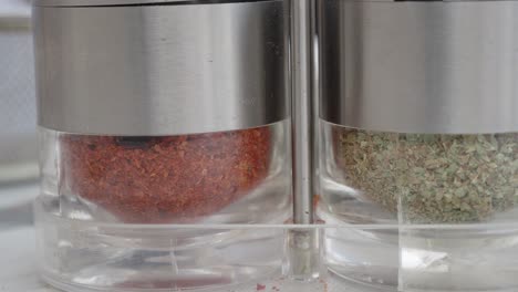 spice jars with red pepper flakes and dried herbs