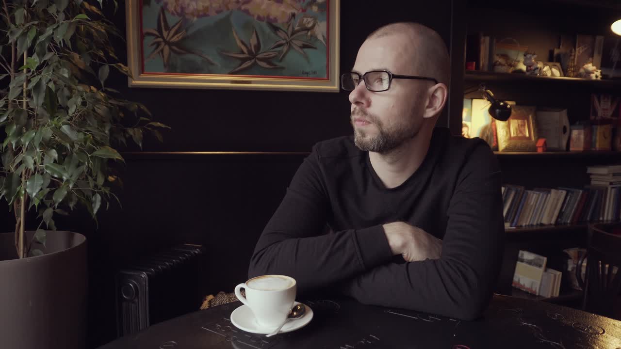 Mann drikker kaffe på en kafé