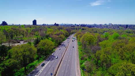 vista de avión no tripulado sobre la i-87 en el bronx, mostrando una carretera despejada, parques verdes y el horizonte de nueva york