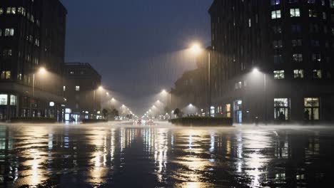 street lights illuminating empty city street during heavy rainfall at night, creating moody and atmospheric scene with reflections on wet asphalt