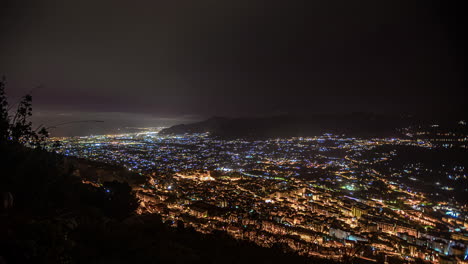 mirando la ciudad de palermo, sicilia por la noche - nubes de lapso de tiempo que vienen del mar