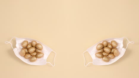 golden easter eggs appear in face masks on beige background. stop motion