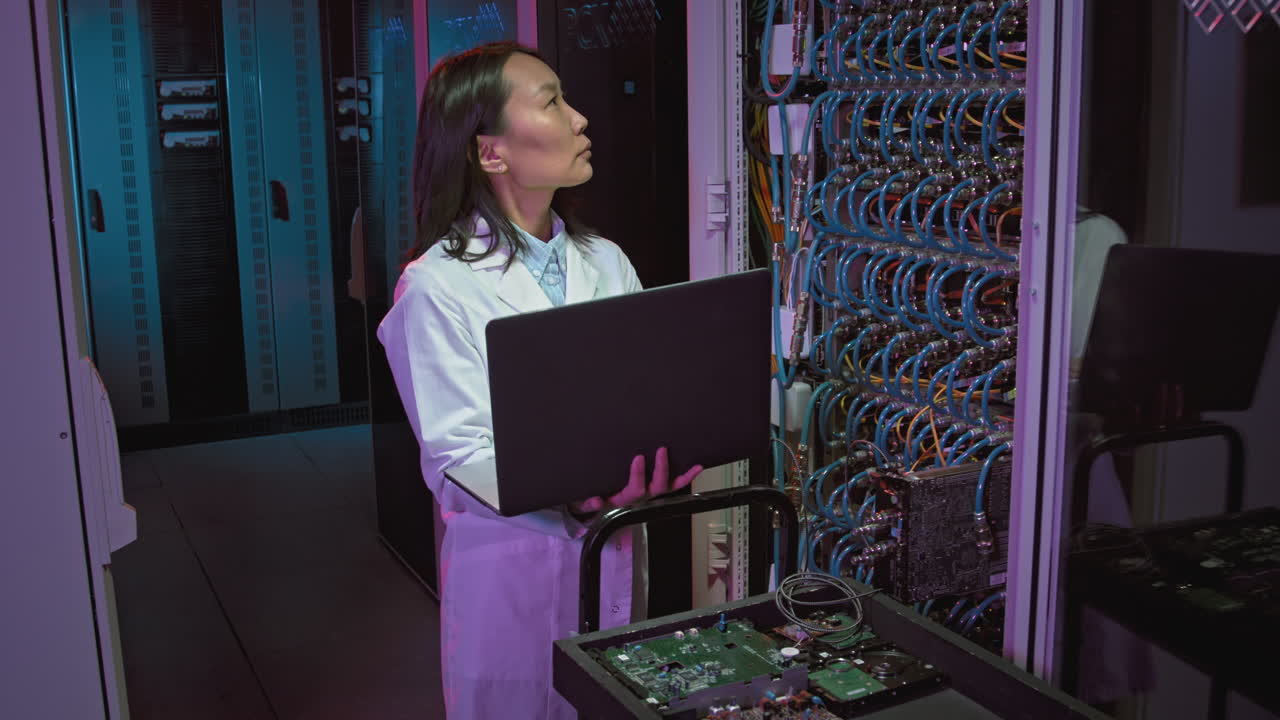 Female IT Specialist Checking Equipment in Data Center