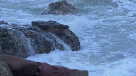 Big-stormy-waves-breaking-against-abandoned-seaside-fortification-building-ruins-at-Karosta-Northern-Forts-in-Liepaja,-medium-closeup