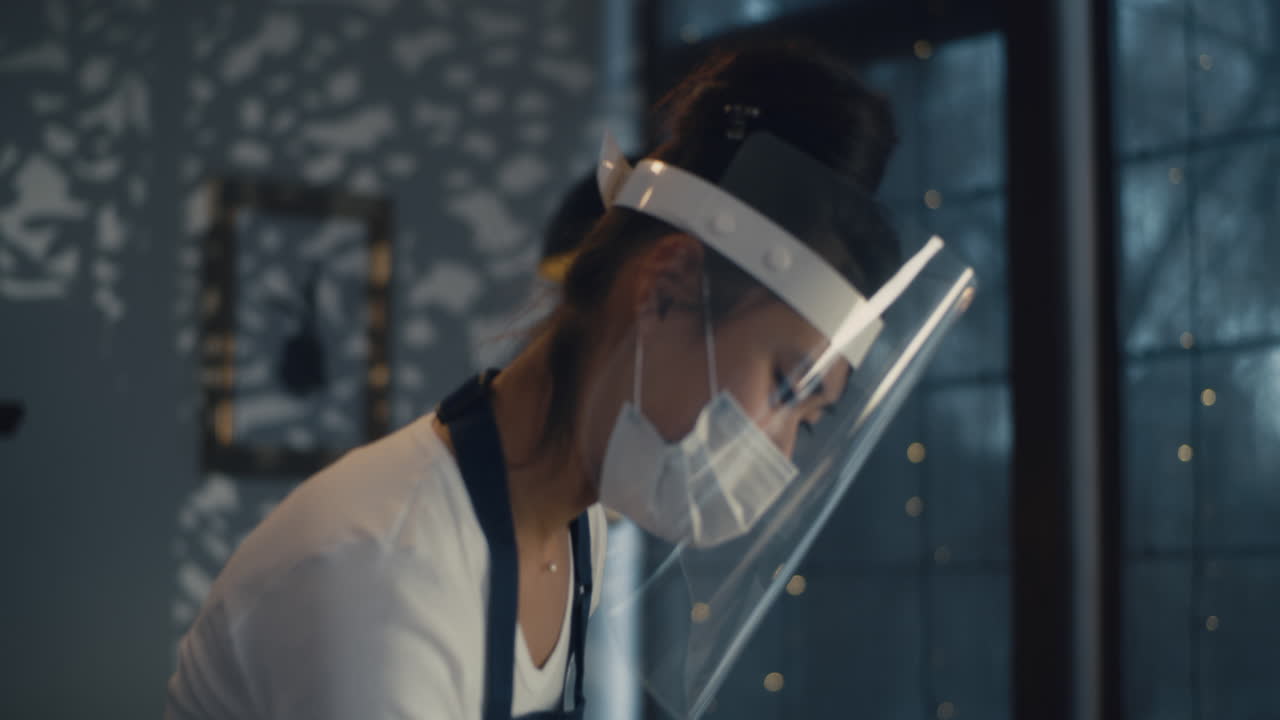 Server in protective gear writing on notepad