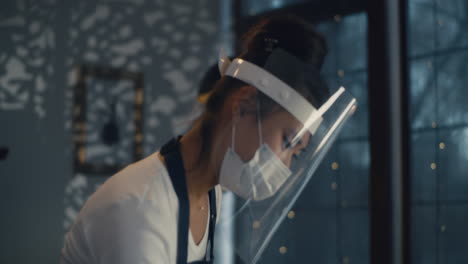 server in protective gear writing on notepad