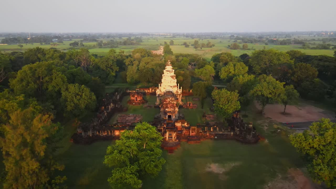 AERIAL: wide shot of an ancient temple in Thailand at dawn. Flying forward.