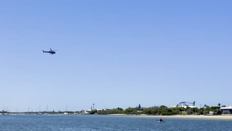 helicopter approaches and lands near the water