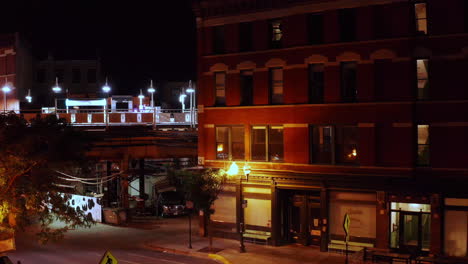 a dolly zoom shot of a old motel building next to a rail train station in the old streets of chicago late at night