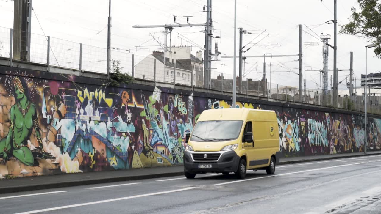 Mit Graffiti besprühte Stadtmauer mit gelbem Lieferwagen