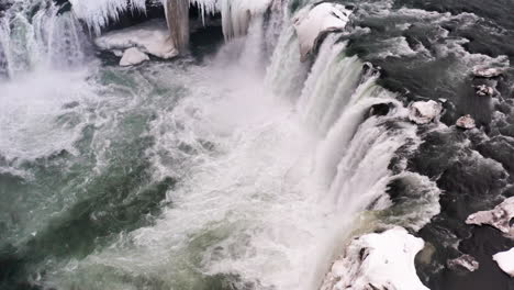 Goðafoss-Waterfall-and-River-Skjálfandafljót-in-North-Iceland-in-Winter,-Aerial-Close-Up-View-of-Cold-Water-Flow,-Famous-Touristic-Destination