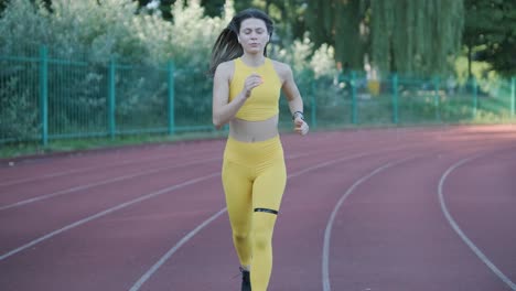 woman running on outdoor track in yellow sportswear