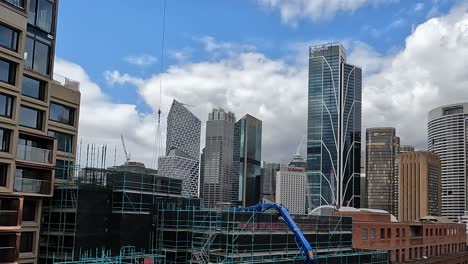 sydney city skyline with tower crane deliving construction materials on building site