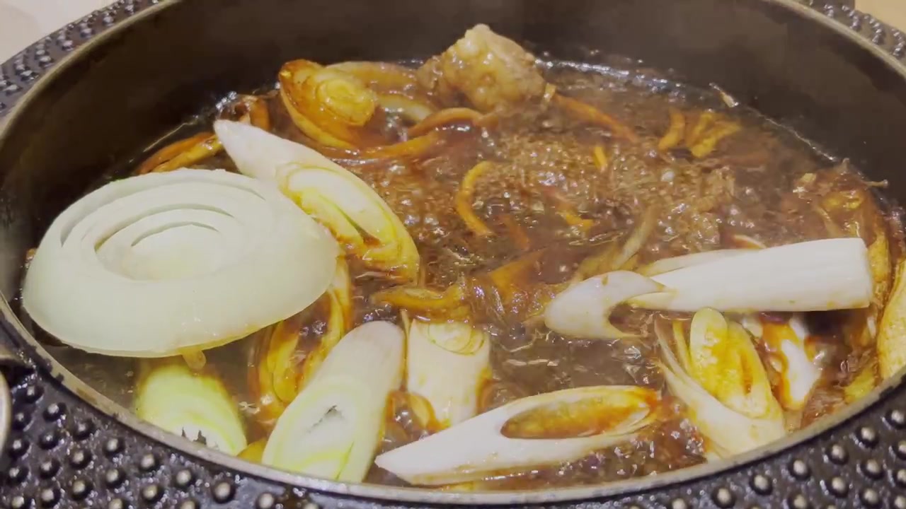 Video ravvicinato di brodo nero di sukiyaki giapponese che bolle vigorosamente in un hot pot. Zuppa fumante che sobbolle in una pentola tradizionale, mostrando l'autentica cucina giapponese hot pot e un'atmosfera calda e accogliente.