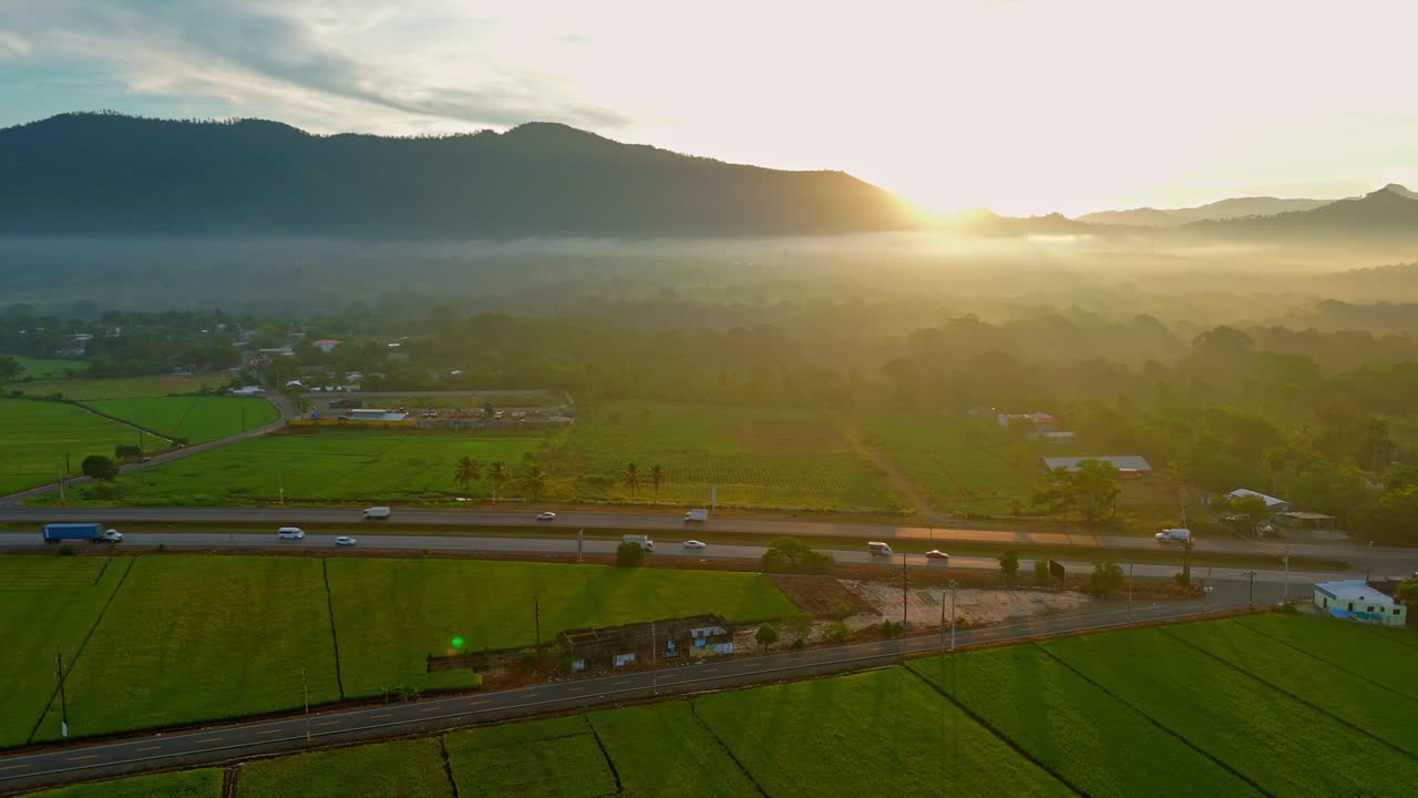 Sunrise drone flight over Duarte Highway reveals a scenic rural landscape in the Dominican Republic. Backward dolly out