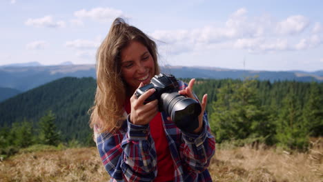 mujer con una cámara fotográfica en las manos. fotógrafo mirando imágenes en la cámara