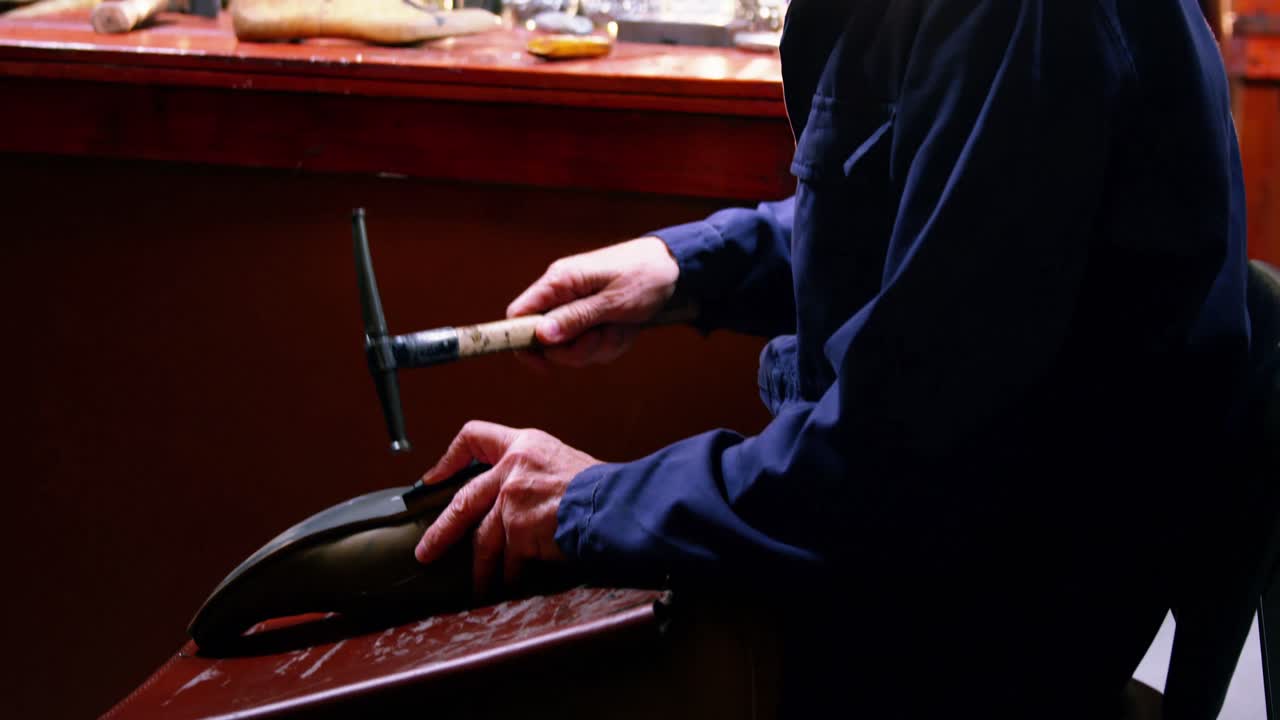 Shoemaker hammering on a shoe