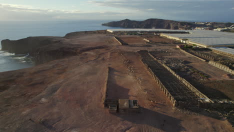 Aerial-view-in-reverse-on-a-flock-of-sheep-and-goats-running-through-a-desert-landscape-and-near-the-coast