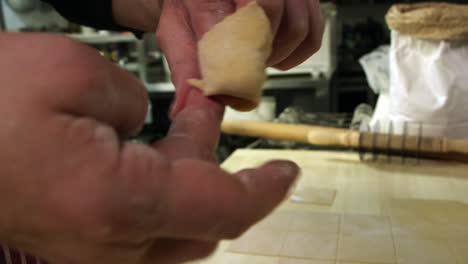 plegando cappelletti de pasta fresca. cierra las manos.