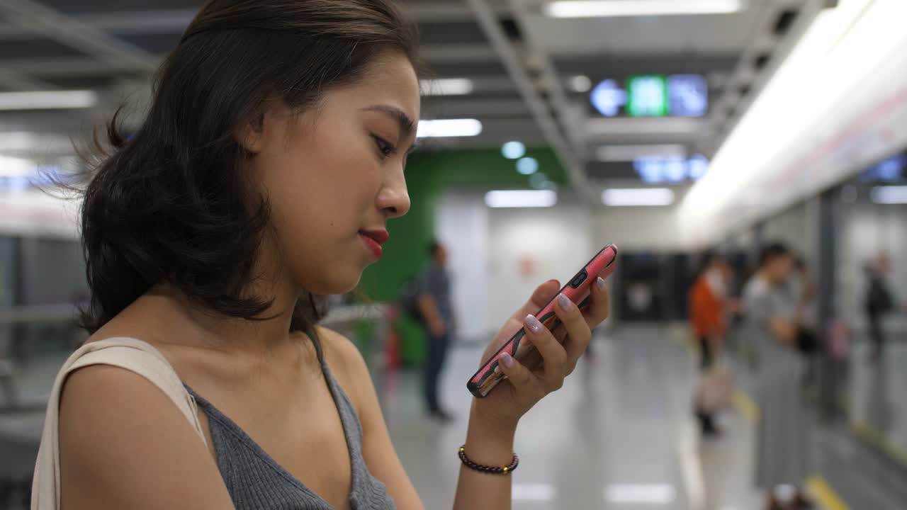 지하철역에서 전화를 사용하는 젊은 여성,4k