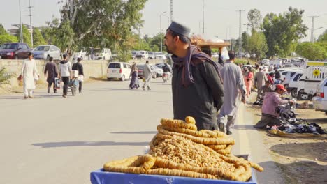 a street vendor selling fresh dried figs on a cart in a busy public marketplace with people walking in the background.