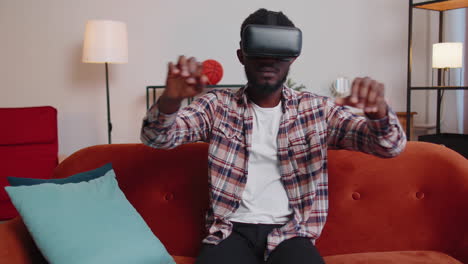 young man use virtual reality headset glasses at home, enjoying video concept moving hands in air