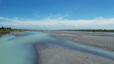 Fast-upstream-aerial-of-beautiful-turquoise-colored-Waimakariri-River-in-summertime