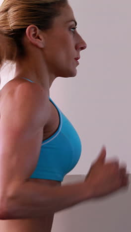 mujer súper en forma corriendo en la cinta de correr