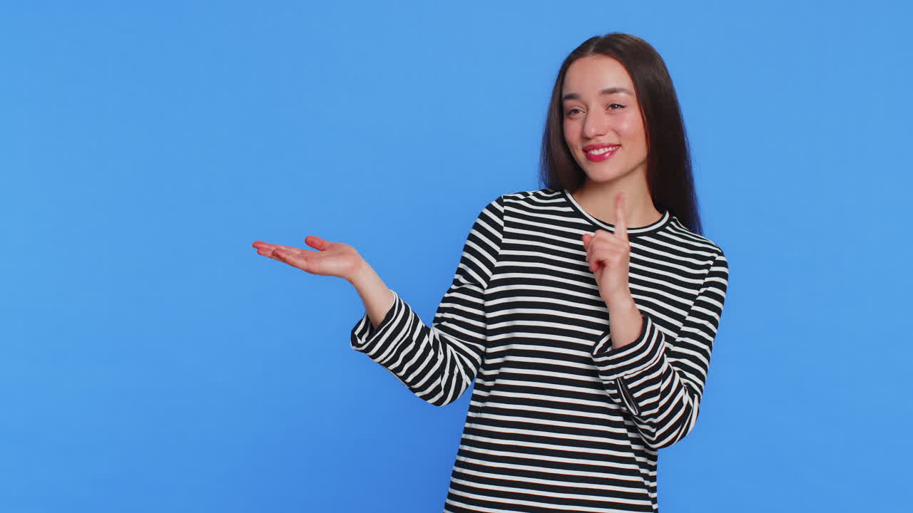 젊은 여성이 엄지손가락을 올리고 광고 로고를 위해 빈 공간에 왼쪽을 가리키고 있습니다.