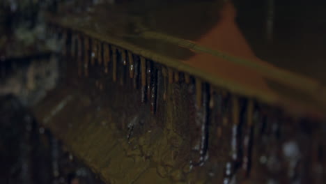 wood varnish dripping over container in garage workshop - close up