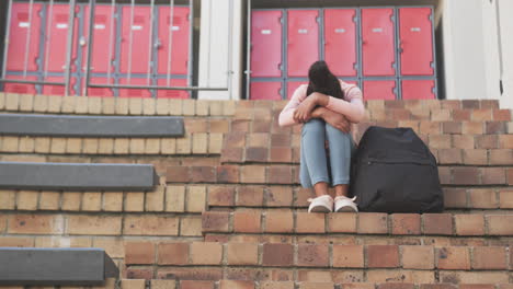 sitting on school steps, student with backpack feeling sad and lonely, copy space