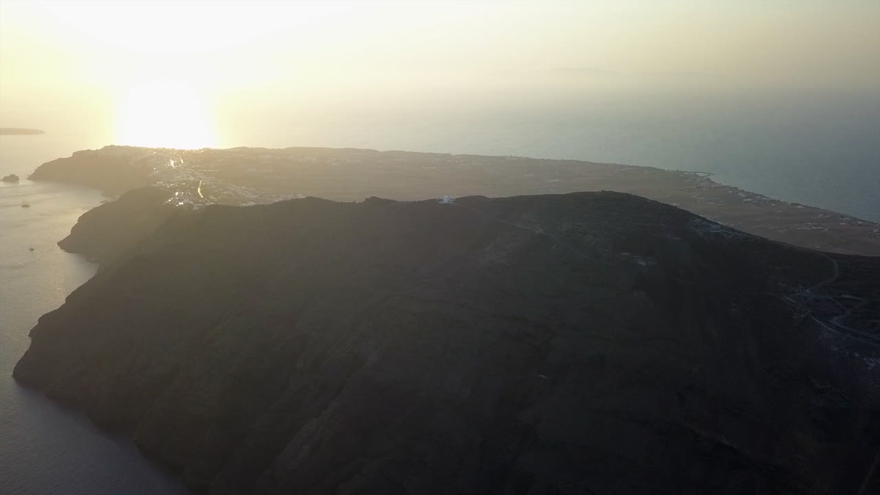 Rising sunset aerial of mountain top Profet Elias church on Santorini